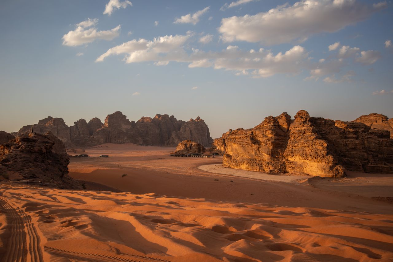 Desert buttes under the Milky Way with a warm horizon glow